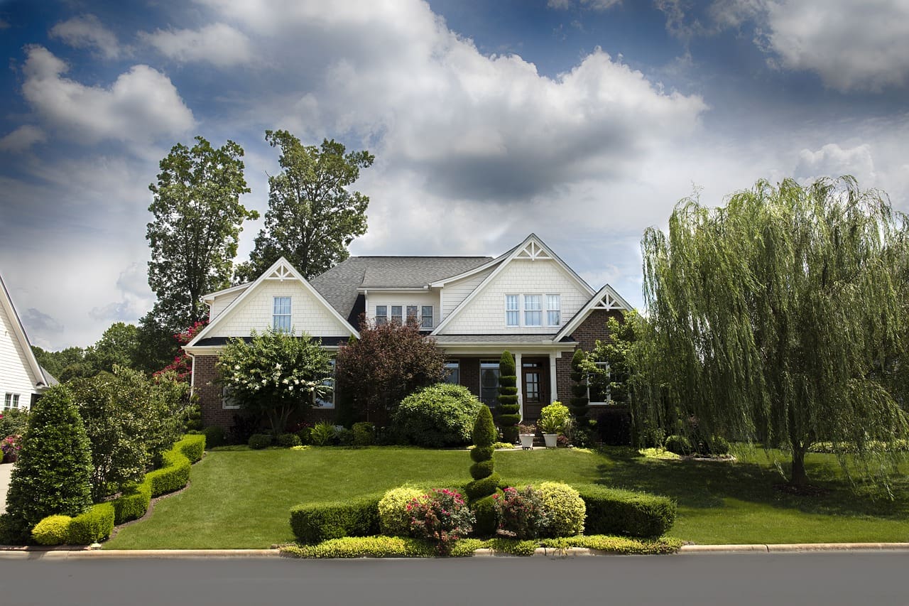 A large white house sitting on top of a lush green hillside.